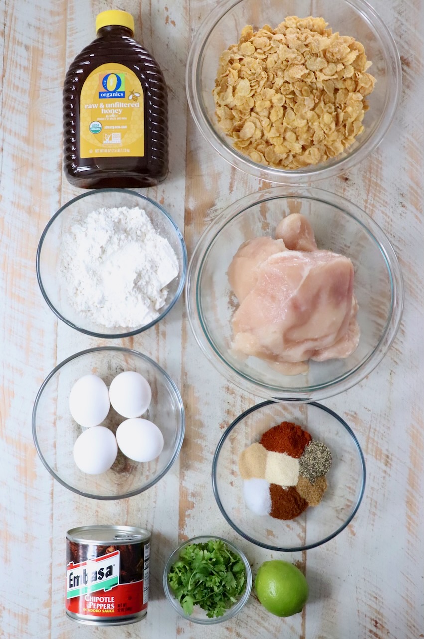 ingredients for honey chipotle chicken crispers on a white wood board