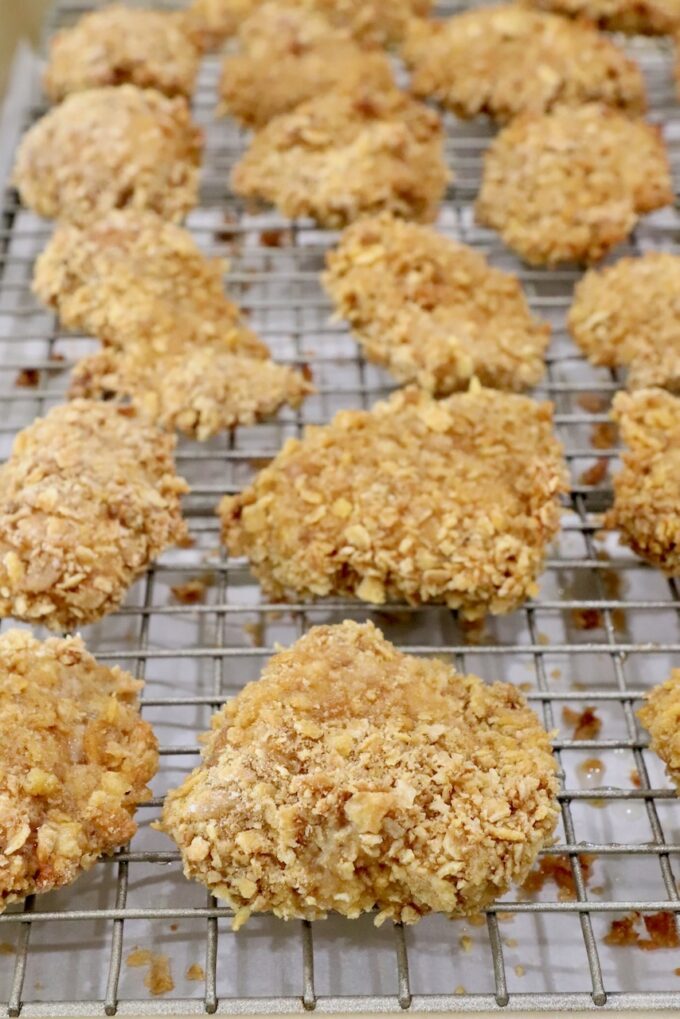 cooked breaded pieces of chicken on a wire rack on top of a baking sheet