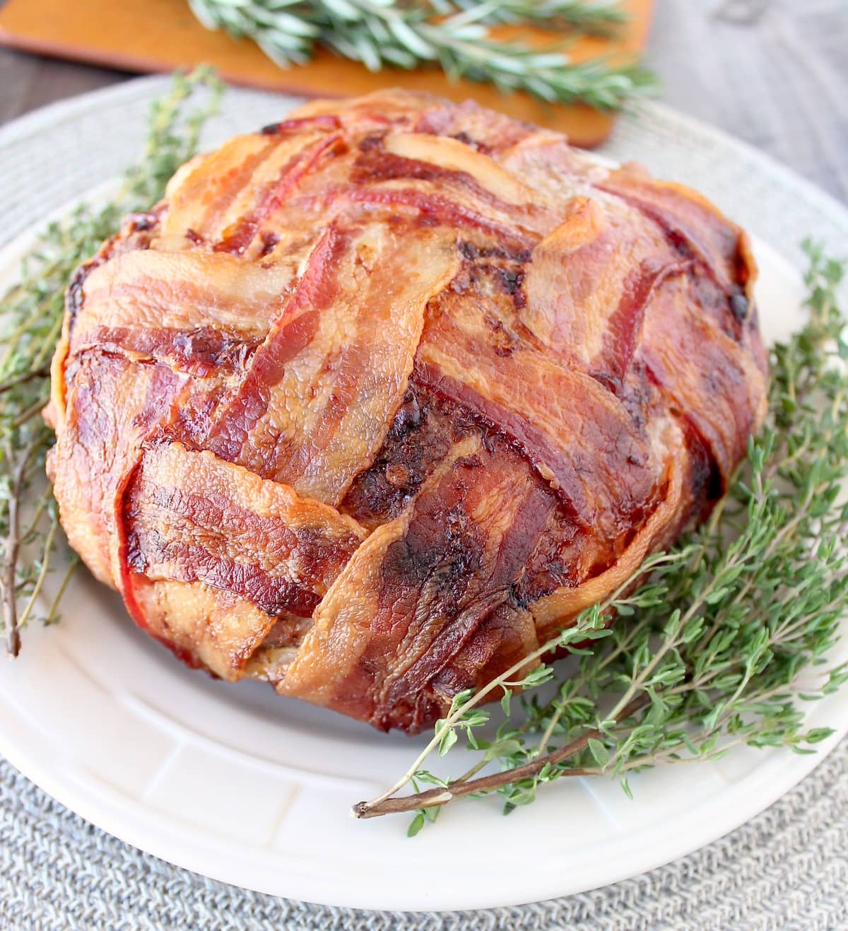 Bacon Wrapped Meatloaf on plate with fresh thyme sprigs