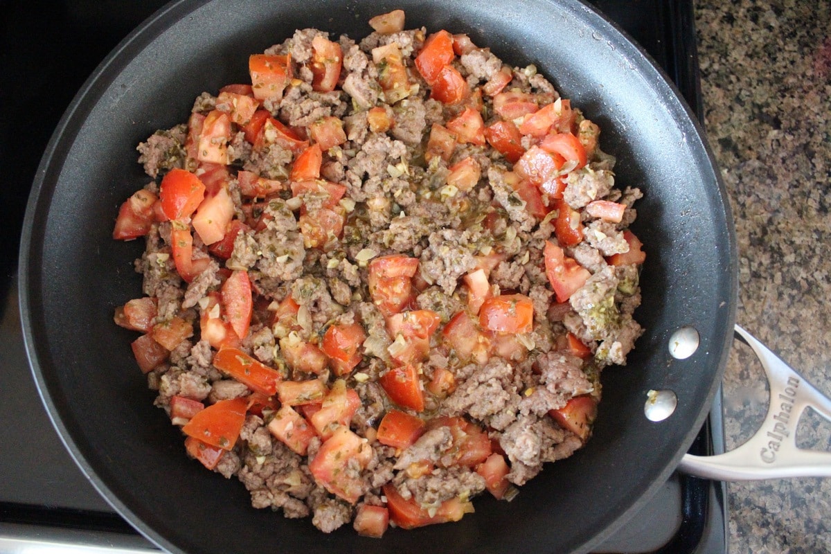 diced tomatoes and cooked ground turkey sausage in a skillet