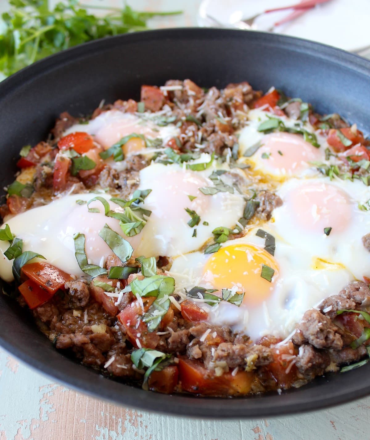 cooked eggs on top of cooked turkey sausage in a skillet