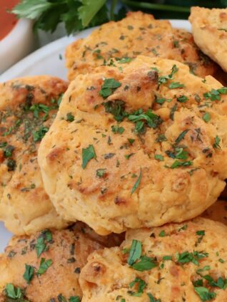 cheddar biscuits stacked up on a plate