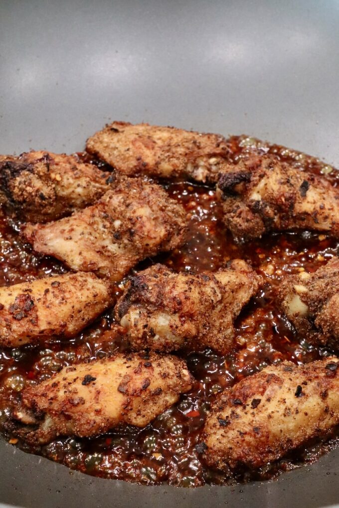 cooked chicken wings in a wok with sauce