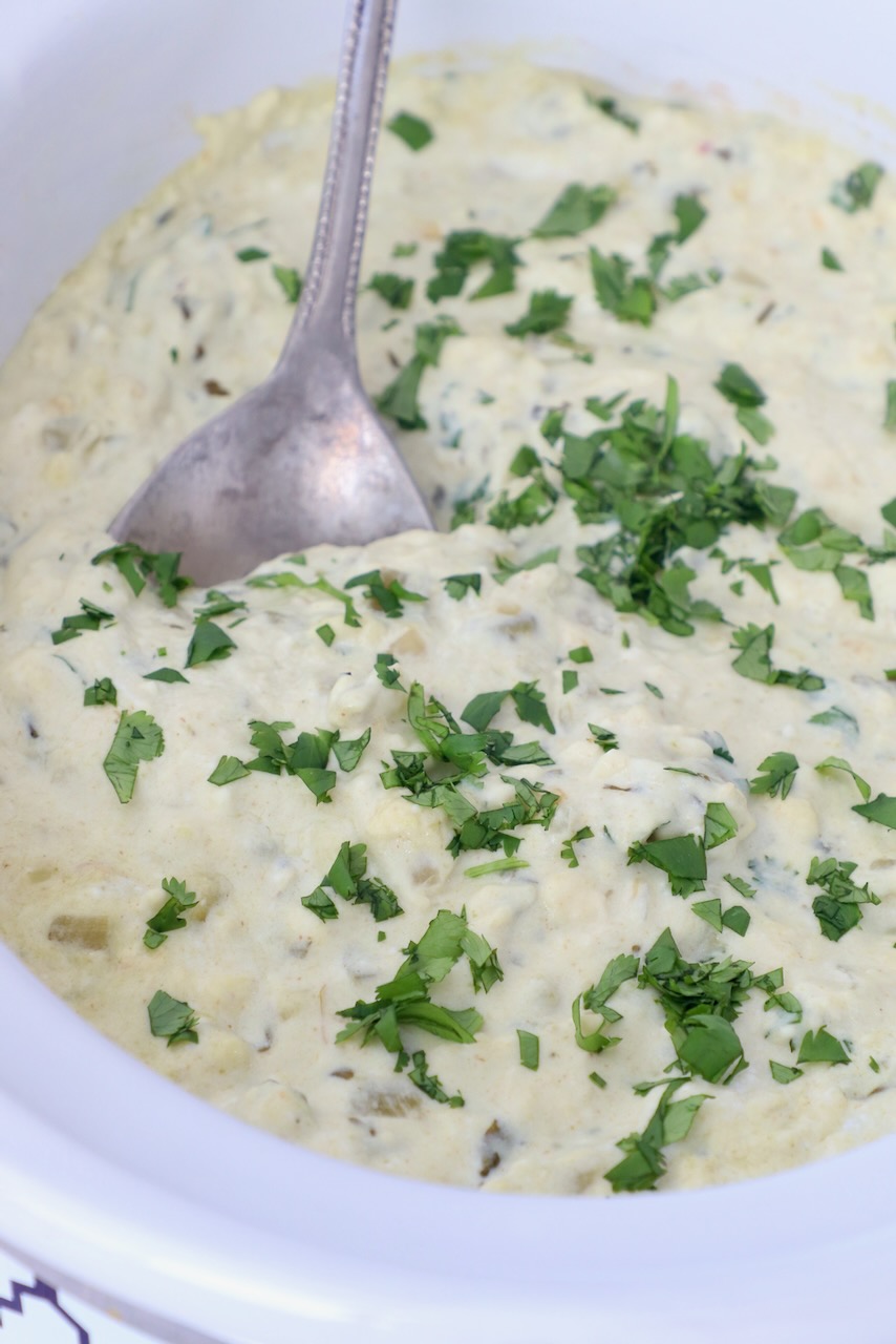 white queso in slow cooker with serving spoon