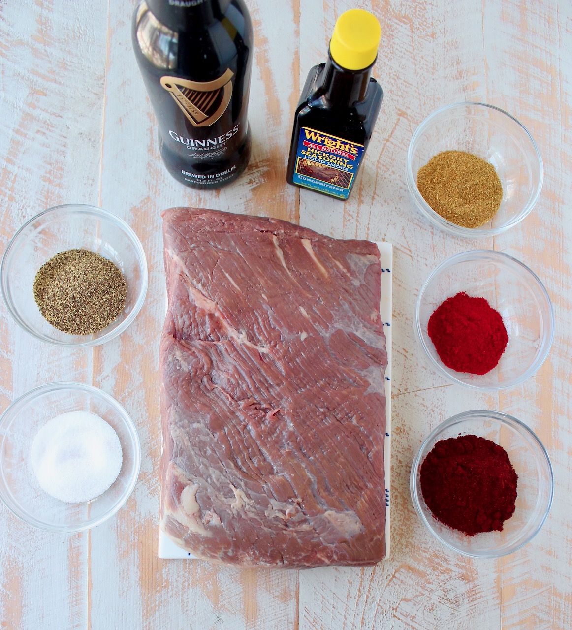 ingredients for brisket tacos on a white wood board