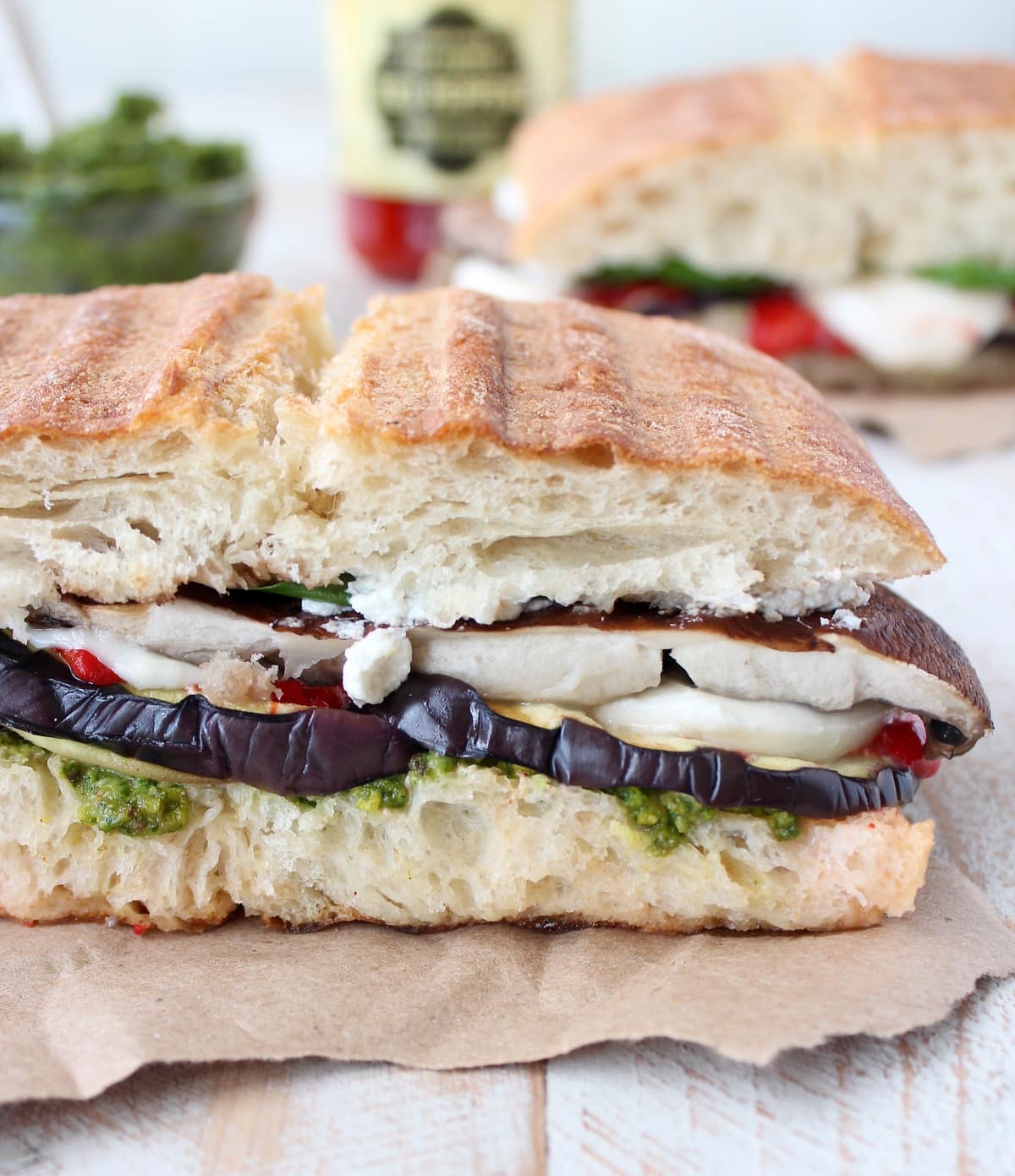 Vegetarian Italian Panini on a piece of paper on a white wood board