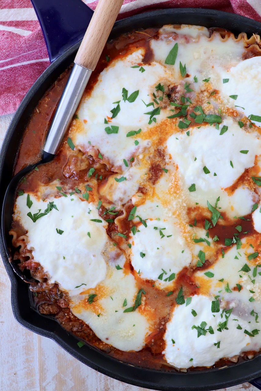 cooked lasagna in skillet with serving spoon