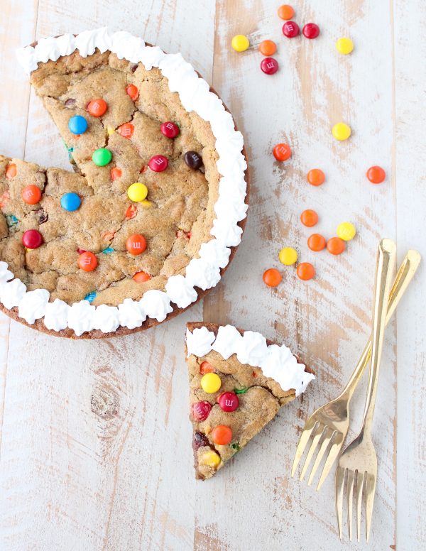 The Ultimate Candy Cookie Cake recipe is perfect for Halloween, birthdays or holidays, add your favorite candy to cookie dough & bake into a tasty cake!