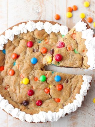 The Ultimate Candy Cookie Cake recipe is perfect for Halloween, birthdays or holidays, add your favorite candy to cookie dough & bake into a tasty cake!