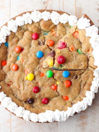 The Ultimate Candy Cookie Cake recipe is perfect for Halloween, birthdays or holidays, add your favorite candy to cookie dough & bake into a tasty cake!