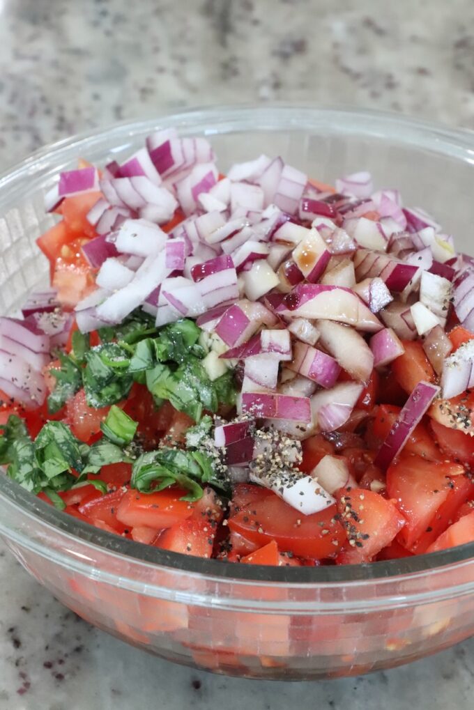 diced tomatoes, onions and basil in a glass bowl