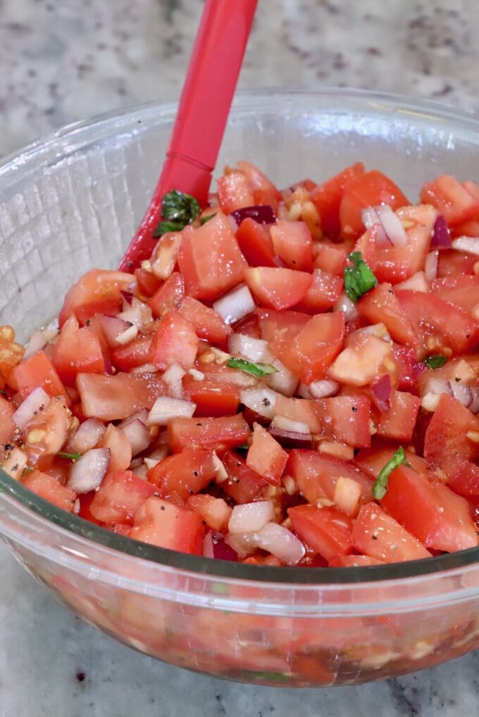 tomato bruschetta mixed together in a glass bowl