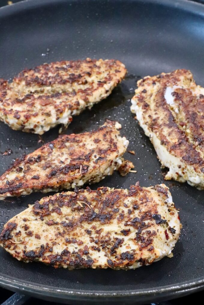 seared seasoned chicken breasts in a skillet