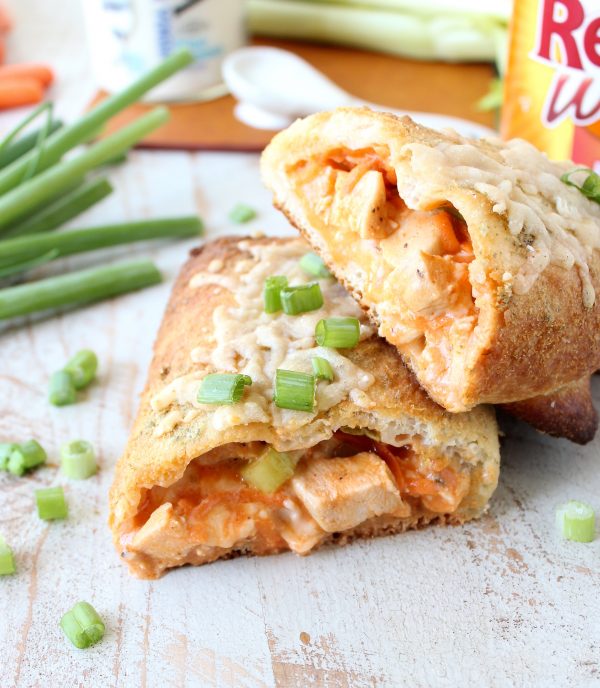 Two halves of a buffalo chicken bake stacked together on a wooden surface. 
