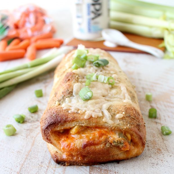 Buffalo Chicken Bake on a wooden surface garnished with green onions. 