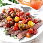 In this delicious recipe, Italian seasoned flank steak is cooked in a cast iron skillet or sous vide, then topped with balsamic roasted cherry tomatoes.