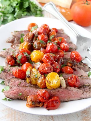 In this delicious recipe, Italian seasoned flank steak is cooked in a cast iron skillet or sous vide, then topped with balsamic roasted cherry tomatoes.