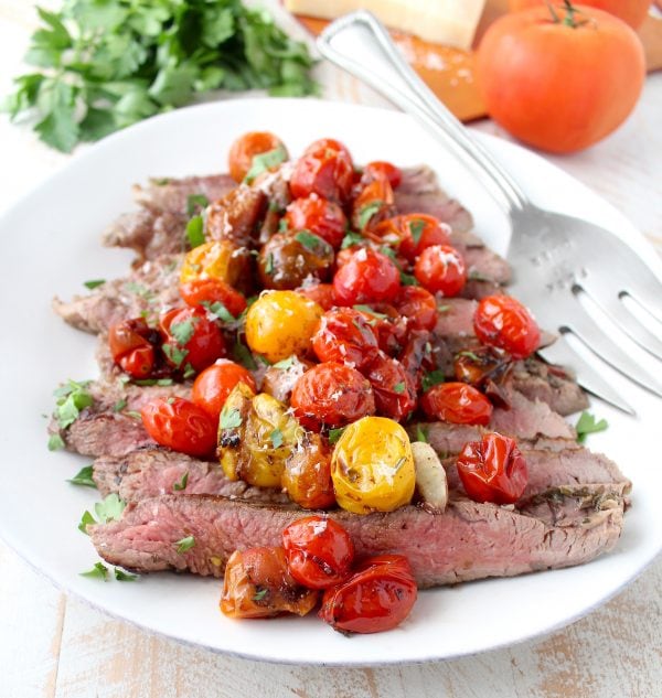 In this delicious recipe, Italian seasoned flank steak is cooked in a cast iron skillet or sous vide, then topped with balsamic roasted cherry tomatoes.