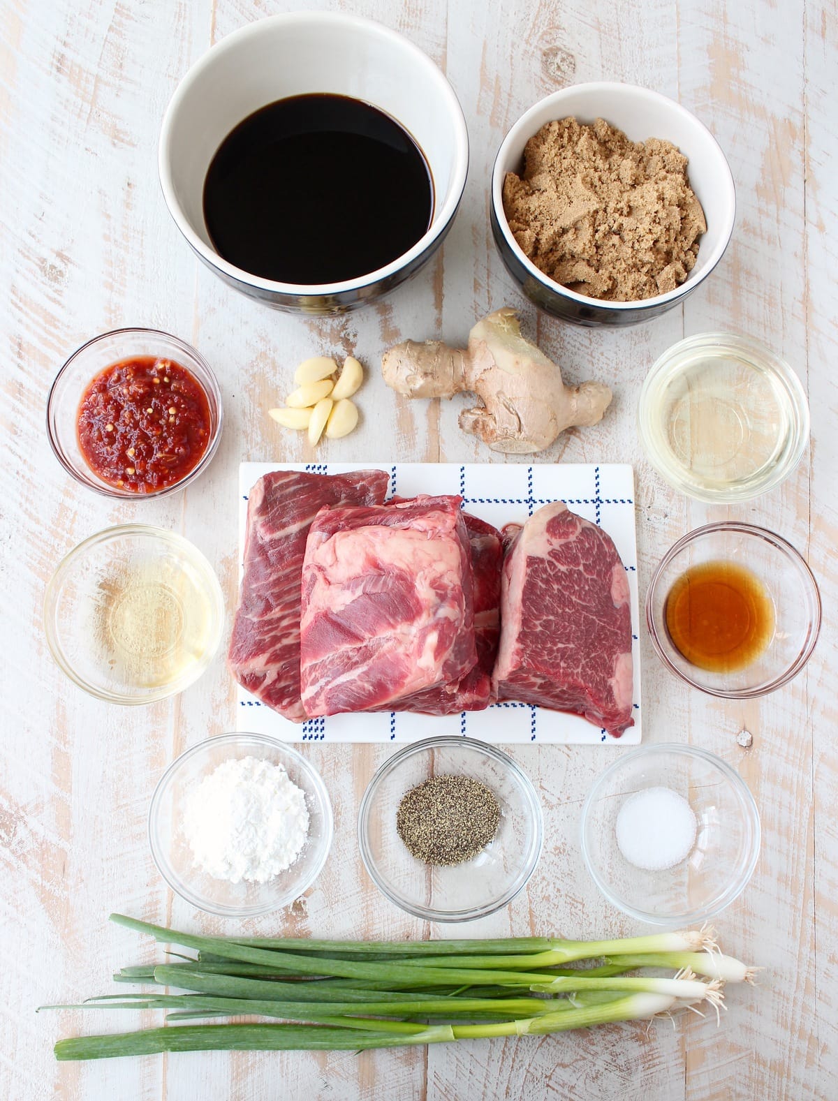 ingredients for korean bbq short ribs on a white wood board