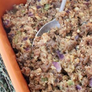 sausage stuffing in a casserole dish with a serving spoon