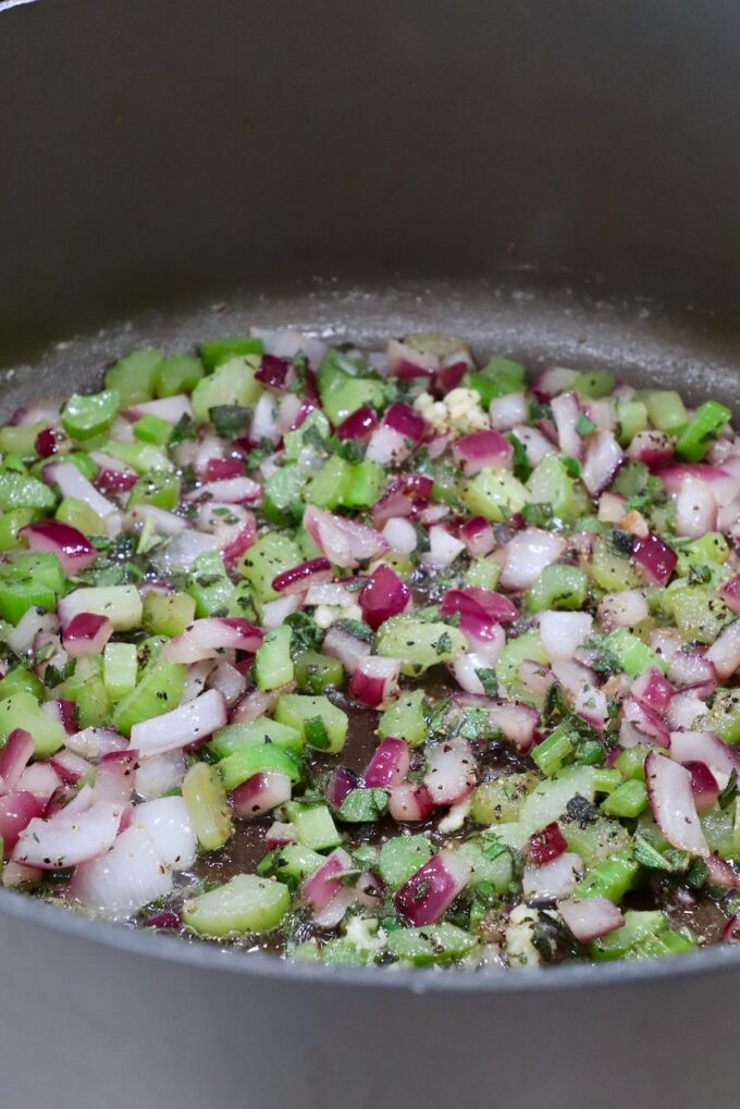 diced onion and celery with seasonings in a large pan