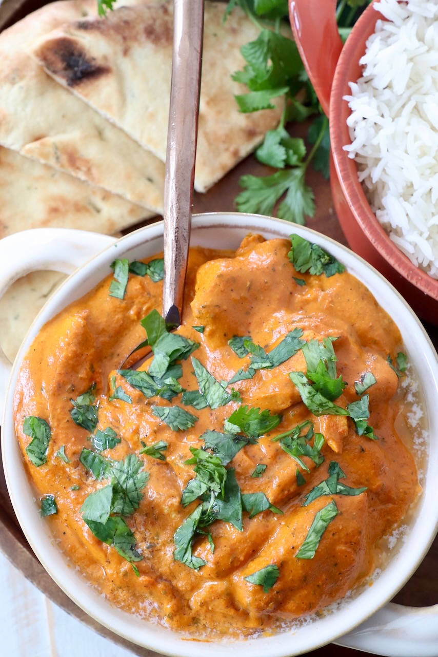 prepared butter chicken in bowl with spoon