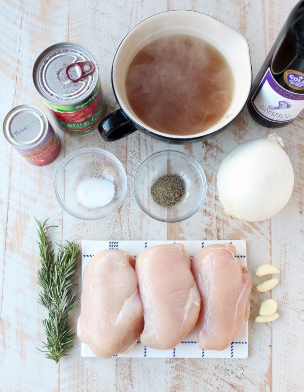 Ingredients for slow cooker chicken ragu on a wooden surface. 