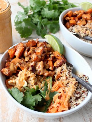 Roasted sweet potatoes and quinoa are topped with delicious Thai peanut sauce in this healthy, gluten free & vegan buddha bowl recipe!