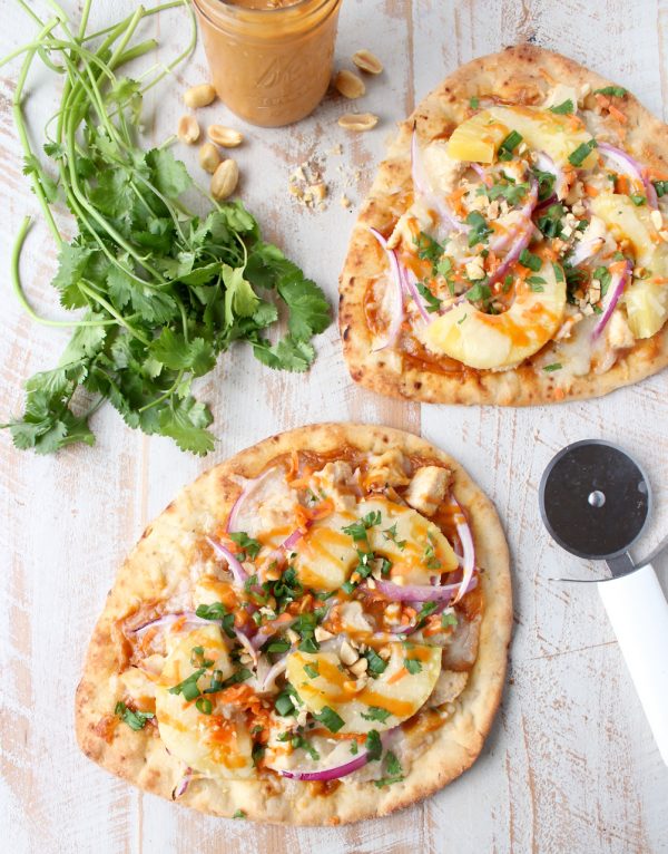 This easy naan pizza recipe is made in under 30 minutes with Thai peanut chicken, red onion, pineapple & mozzarella for a delicious combination of flavors!