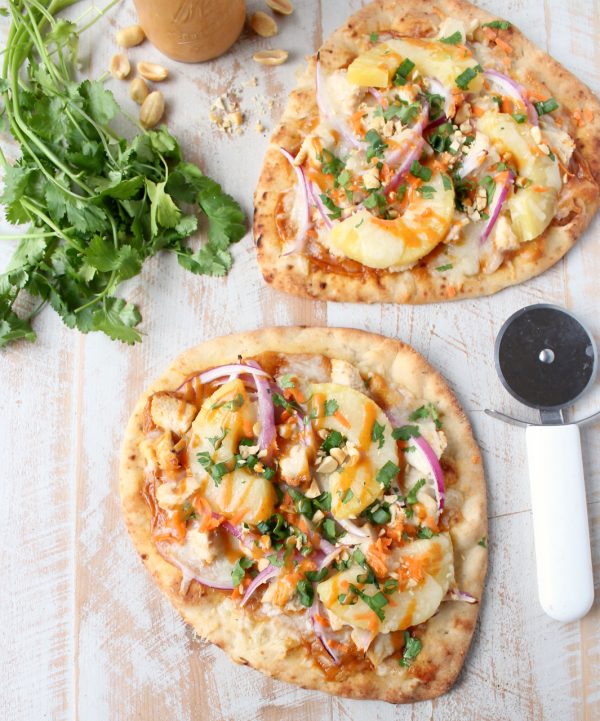 This easy naan pizza recipe is made in under 30 minutes with Thai peanut chicken, red onion, pineapple & mozzarella for a delicious combination of flavors!