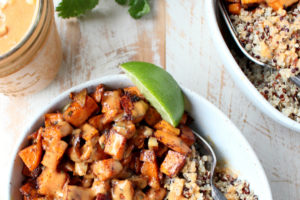 Overhead picture of roasted sweet potato, quinoa and peanut sauce in a bowl with a fork