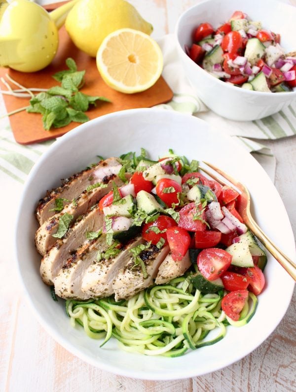 Marinated & grilled Greek Chicken is served on a bowl of zucchini noodles, topped with cucumber tomato salsa for a healthy, gluten free meal made in under 30 minutes!