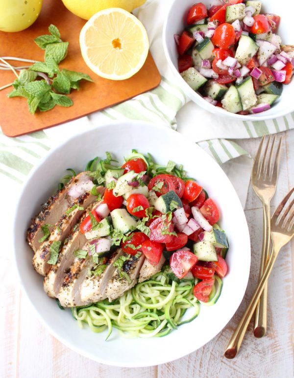 Marinated & grilled Greek Chicken is served on a bowl of zucchini noodles, topped with cucumber tomato salsa for a healthy, gluten free meal made in under 30 minutes!