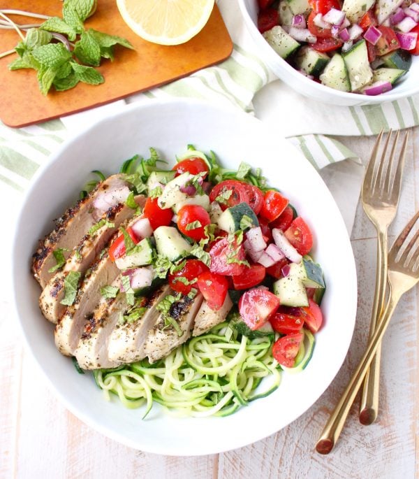 Marinated & grilled Greek Chicken is served on a bowl of zucchini noodles, topped with cucumber tomato salsa for a healthy, gluten free meal made in under 30 minutes!