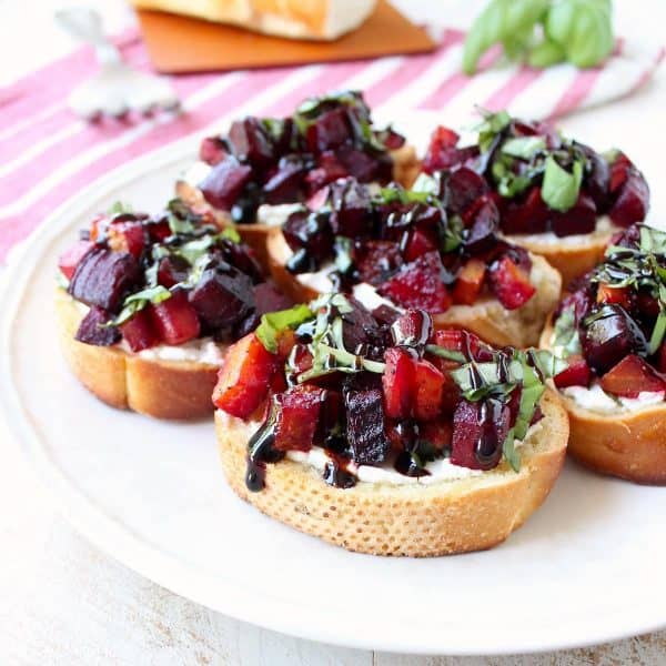 A toasted baguette is topped with goat cheese, balsamic roasted beets, fresh basil & balsamic reduction in this vegetarian Beet Bruschetta recipe that's perfect for Spring!