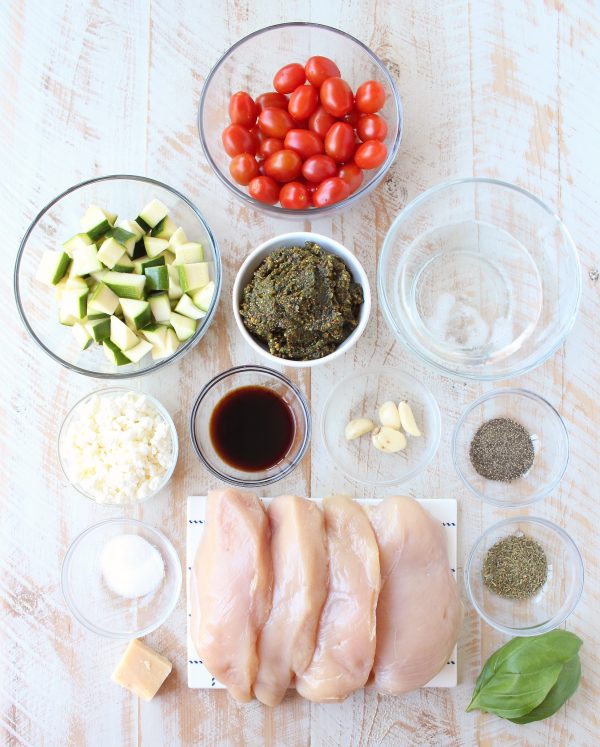 Sheet pan chicken is an easy, gluten free, one pan dish that takes under an hour to make. This recipe is stuffed with pesto and cheese, and served with zucchini and tomatoes!