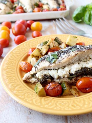 Sheet pan chicken is an easy, gluten free, one pan dish that takes under an hour to make. This recipe is stuffed with pesto and cheese, and served with zucchini and tomatoes!