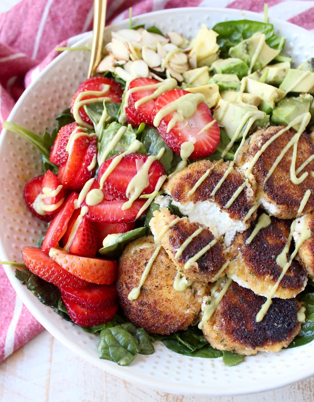 Crispy goat cheese, creamy avocado & juicy strawberries top spinach & arugula, tossed with avocado vinaigrette, for the perfect vegetarian Spring salad!