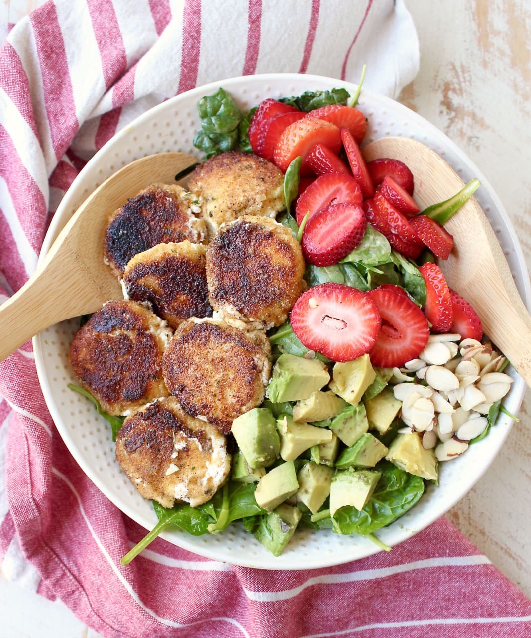 Crispy goat cheese, creamy avocado & juicy strawberries top spinach & arugula, tossed with avocado vinaigrette, for the perfect vegetarian Spring salad!