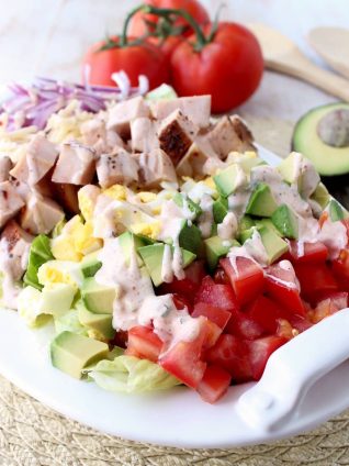 This gluten free Cobb Salad recipe is colorful, flavorful & so easy to make! It's topped with Cajun turkey, avocado, tomatoes & creamy Cajun ranch dressing!