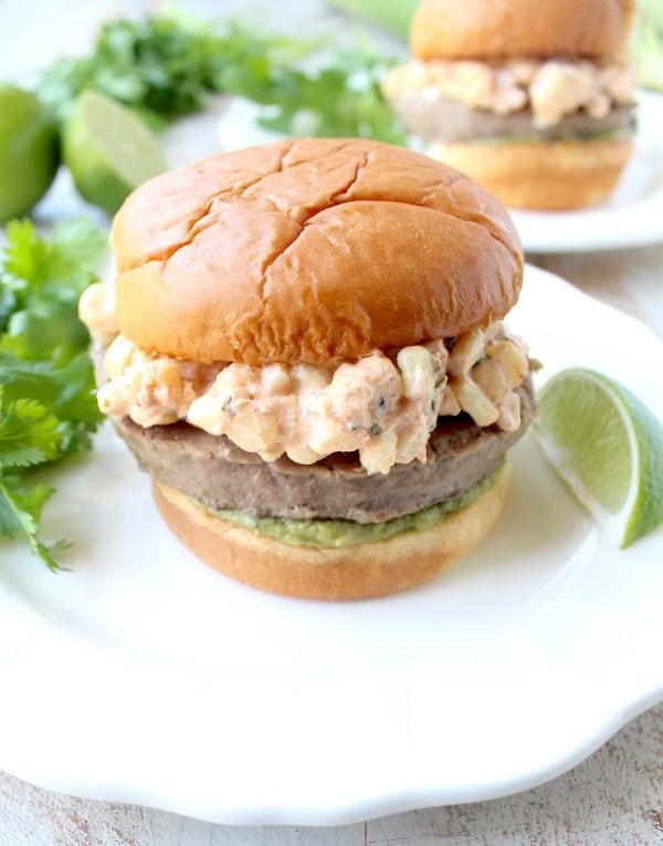 Mexican turkey burgers are covered in cotija cheese, guacamole and grilled Mexican street corn for a flavorful summer burger recipe!