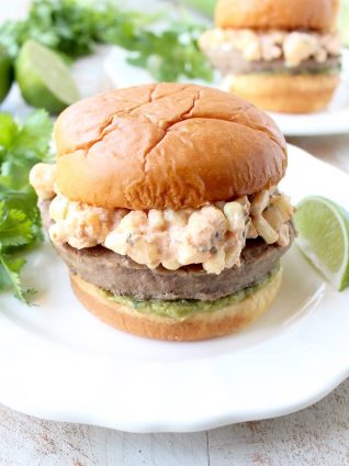 Mexican turkey burgers are covered in cotija cheese, guacamole and grilled Mexican street corn for a flavorful summer burger recipe!