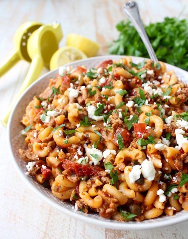 In just one pot and under 45 minutes, make a delicious Greek Pasta recipe filled with sun dried tomatoes, ground turkey, capers and feta cheese!