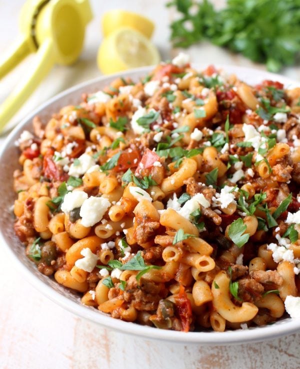 In just one pot and under 45 minutes, make a delicious Greek Pasta recipe filled with sun dried tomatoes, ground turkey, capers and feta cheese!