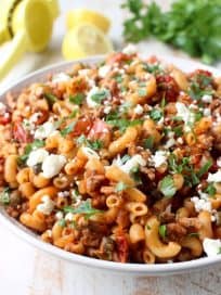In just one pot and under 45 minutes, make a delicious Greek Pasta recipe filled with sun dried tomatoes, ground turkey, capers and feta cheese!