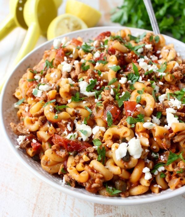 In just one pot and under 45 minutes, make a delicious Greek Pasta recipe filled with sun dried tomatoes, ground turkey, capers and feta cheese!