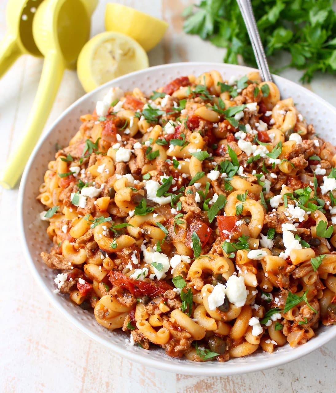 cooked pasta with ground turkey, tomatoes and feta cheese in white bowl