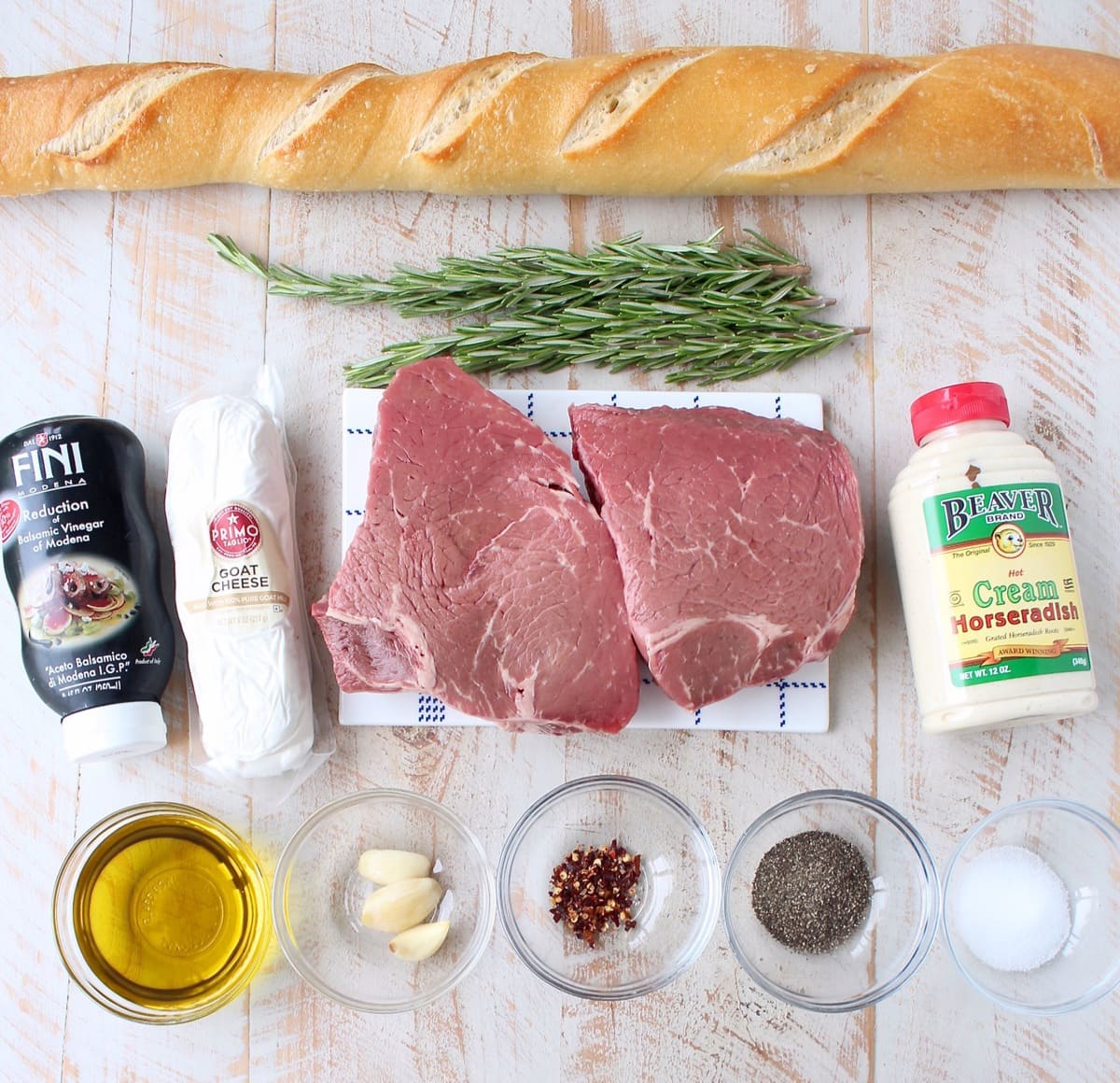ingredients for top sirloin steak crostini on white wood board