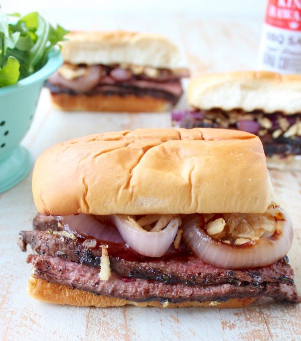 Thin slices of coffee rubbed, grilled steak are piled up with herbed goat cheese, BBQ sauce & grilled onions in this mouth-watering steak sandwich recipe!