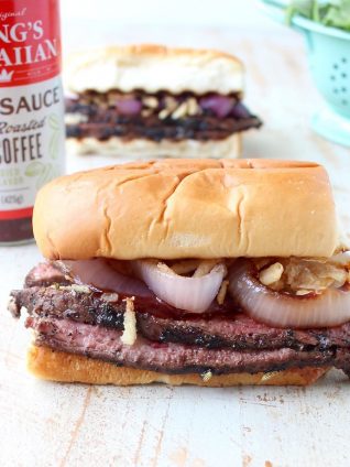 Thin slices of coffee rubbed, grilled steak are piled up with herbed goat cheese, BBQ sauce & grilled onions in this mouth-watering steak sandwich recipe!